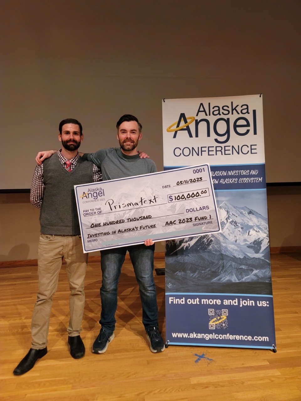 Biznesmen z anielskimi skrzydłami analizujący pitch deck na tablecie w biurze