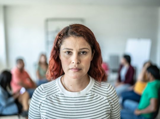 Młody przedsiębiorca drapie się po głowie przy biurku z laptopem i spadającymi wykresami