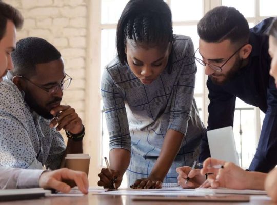 Zespół menedżerów w sali konferencyjnej analizuje dane kryzysowe na dużym ekranie