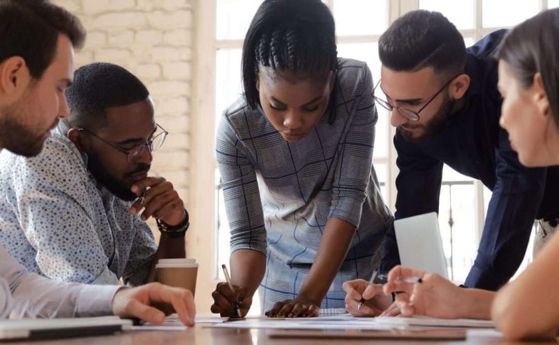 Zespół menedżerów w sali konferencyjnej analizuje dane kryzysowe na dużym ekranie
